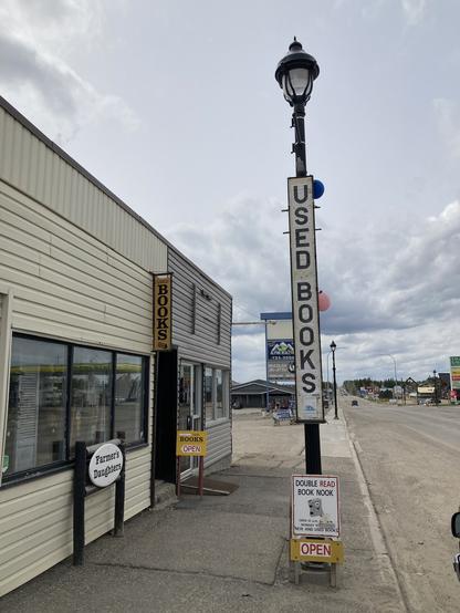 The outside of The Double Read Book Nook, in Edson, Alberta. It has a large old fashioned lamp post, with a sign for the store hanging outside that reads: BOOKS.