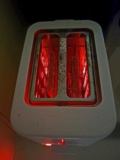 Toast toasting in the toaster, round side down.  The filaments glow red.