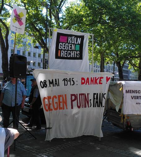 Transpi oben: "Köln gegen rechts", unten: "08. Mai 1945: Danke ❣️, Gegen Putins Fans"