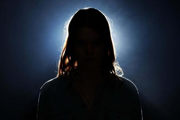 a stock photo of a person in silhouette, with a light source beyond them making them appear to glow