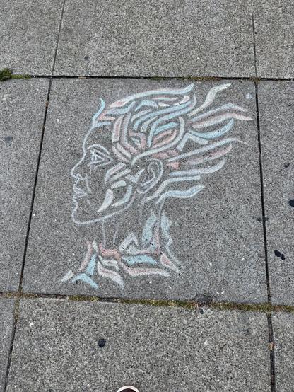 Another drawing by Chalk Visions on the sidewalk. This is a profile drawing of a person's head. There are stylized shapes all around the head, that sort of look like flames. The drawing uses white, red, and blue chalk.