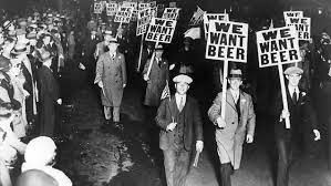 People marching with signs that read "We Want Beer."