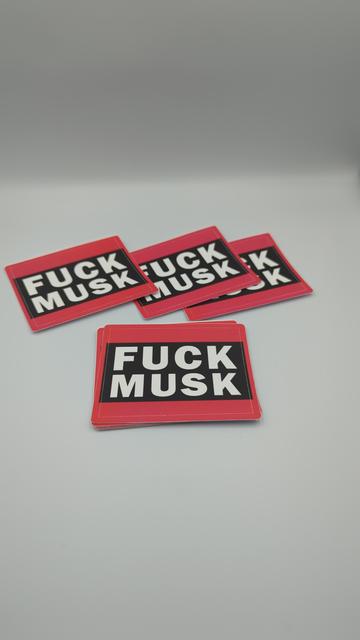 A photo of several stickers against a white background. The design is the words: "fuck musk" in thick, bold capital sans-serifs. A thick red bar fills the space above and below the words.