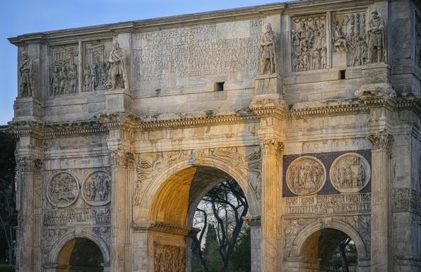Featuring the top part of the Arch of Constantine in Rome Italy, showing the historic inscription and other historic reliefs.