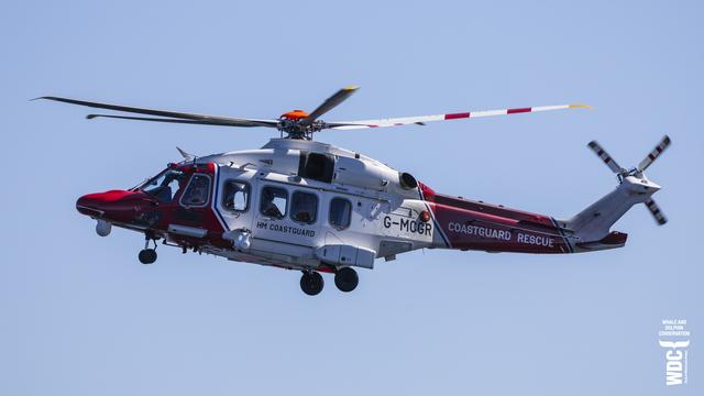 Rescue Helicopter from HM Coastguard Inverness flying in clear blue sky.
