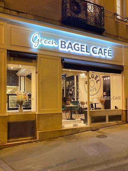 The "Green Bagel Café" storefront at night.