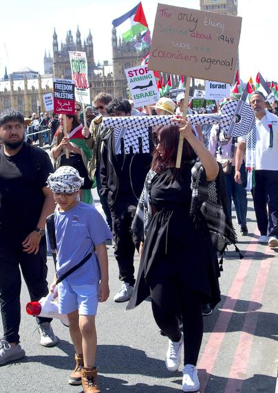woman and son carrying a giant key of return wrapped in keffieh