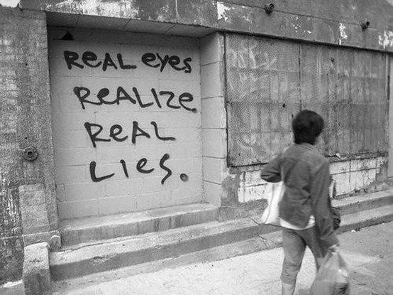 A quote, painted on a wall: "Real eyes realize real lies."