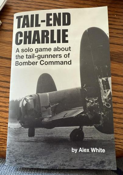 The image features a book titled "Tail-End Charlie" by Alex White, focusing on a solo game about the tail-gunners of Bomber Command. The cover is a black and white photo of the tail section of a damaged RAF Lancaster bomber from WW2