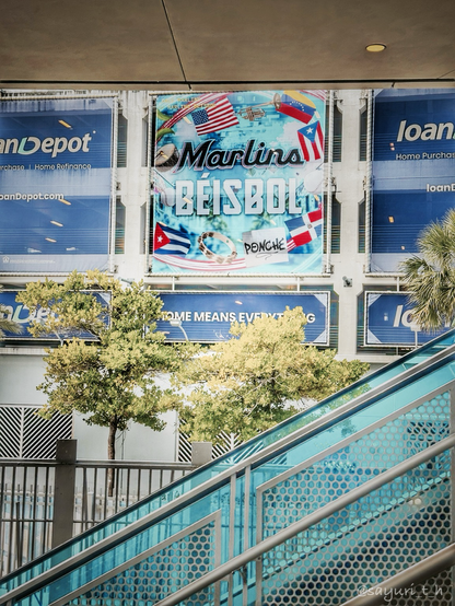 Colorful sign with US and Latin countries flags behind staircase and trees