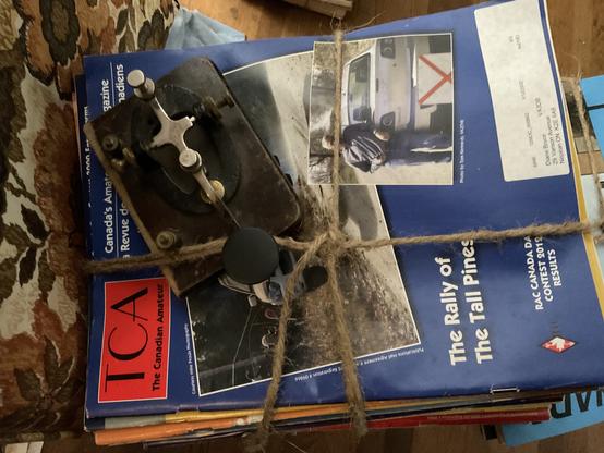 A morse code key along with some magazines