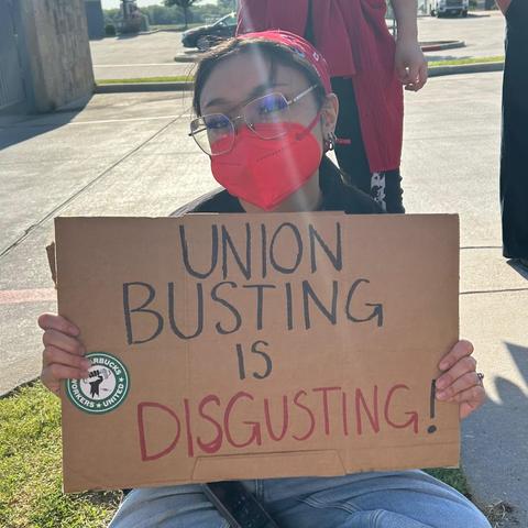text:
  UNION
BUSTING 
       IS
DISGUSTING !

Starbucks Workers United

Image photograph of worker beholding this sign
