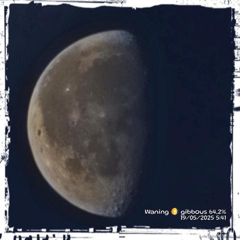 The image shows a close-up view of the Moon against a dark background, likely the night sky. The Moon is in a waning gibbous phase, with 64.2% of its surface illuminated. The right side of the Moon is in shadow, while the left side is brightly lit, revealing its craters and surface details. The image has a textured border, giving it a vintage or artistic appearance. In the bottom right corner, there is text that reads "Waning 🌖 gibbous 64.2% 19/05/2025 5:41," indicating the phase, percentage of illumination, date, and time the photo was taken.