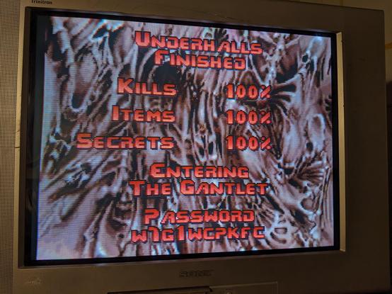 Screen between levels for PlayStation Doom on an old CRT tallying up Kills, Items and Secrets from last level, announcing entering "The Gantlet" a famously misspelled Doom 2 level.