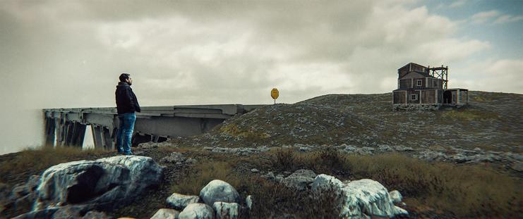 Wide shot, exterior, day -

A long, narrow bridge made up of some strangely carved stone extends out of the frame to the left. On the close side of the bridge, a 3 story wooden structure can be seen sitting on the rugged moor.  A man in a black jeans jacket stands in the foreground.