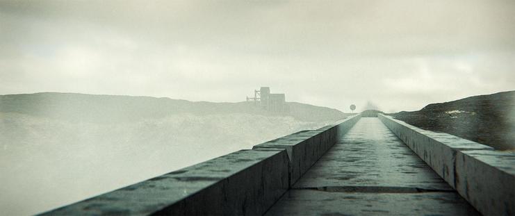 Wide shot, exterior, day -

A long, narrow bridge made up of some strangely carved stone.  At the end, above the cliffside, a 3 story wooden structure can be seen sitting on the rugged moor.