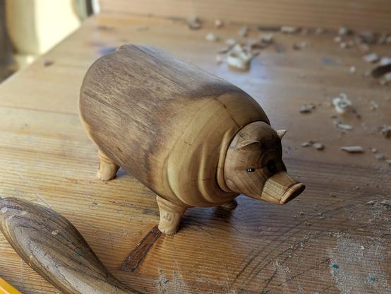 Woodcarved really plump hog on a workbench
