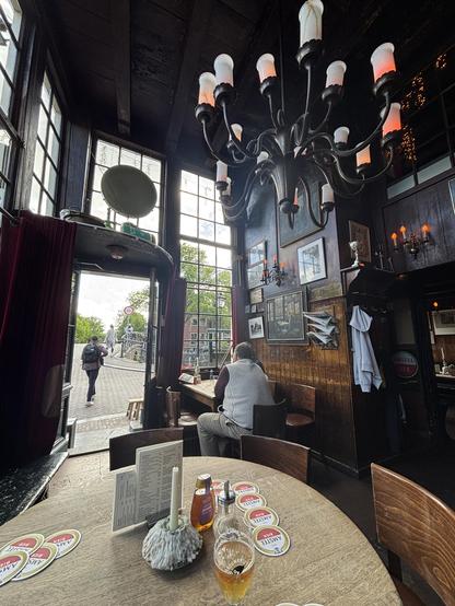 Old bar with timber furniture and a big chandelier.