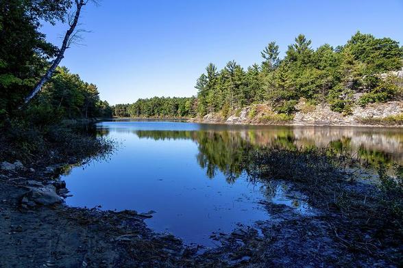 The serene beauty of MacDonald Lake in Ontario, featuring tranquil waters and lush forests, perfect for nature lovers and outdoor enthusiasts.