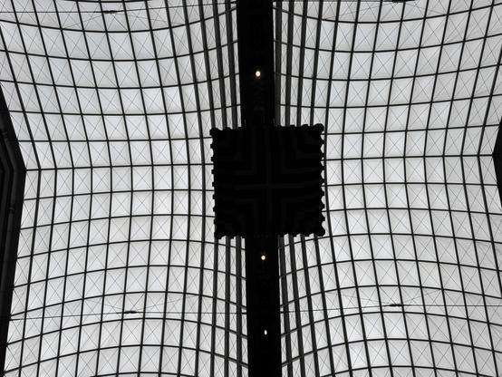 Dark square in the center is the bottom of the central clock. Glass ceiling of the building is above it.
