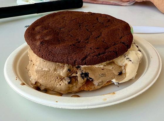 Chocolate chocolate chip cookie sandwich from Cowboy Cookie & Ice Cream. The ice cream visible is Heath Chip and Cookies and Cream.