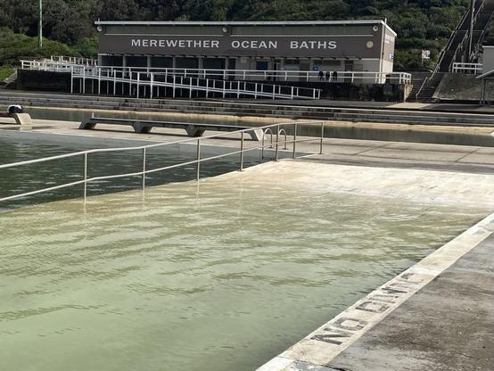 Looking over the wide main pool entry ramp towards the brick Merewether Ocean Baths building. The water over the entry ramp is a tad less clear than normal but not as murky as i expected.