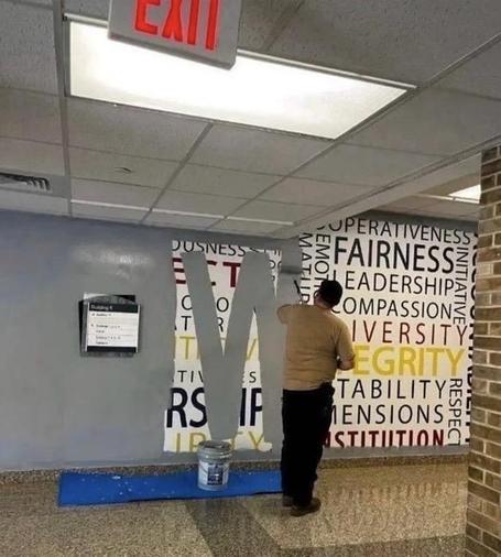 Die Times zeigt einen Einblick in einige der Veränderungen, die beim F.B.I. im Gange sind. Insbesondere in der F.B.I.-Akademie in Quantico am Mittwoch. .... GERECHTIGKEIT ... VIELFALT.... ... INTEGRITÄT ...  MITGEFÜHL . Diese Worte stehen in bunten Farben an einer Wand.
Ein Arbeiter überstreicht sie mit grauer Farbe.
