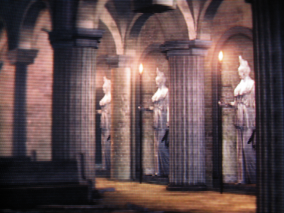 A row of three statues holding torches next to the pews of the Undead Parish.