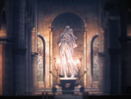The central mother-and-child statue in the Undead Parish, lit by torch-light, overlooking a Fire Keeper's soul.