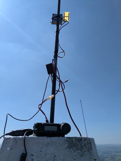 Alternative view of the trig point with the Yaesu FT-857 clearly in view. The fibreglass mast is behind the radio. The messy cables running up the mast to the SG-Lab transverter probably looks even worse than the other photo. The transverter (silver metal box) and PCB antenna are visible at the top of the photo.