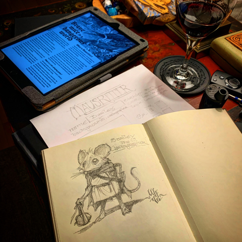 Photo of an open sketchbook with a rough drawing of an anthropomorphic mouse.