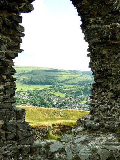 View of message through large arched stone window of ruined castle
