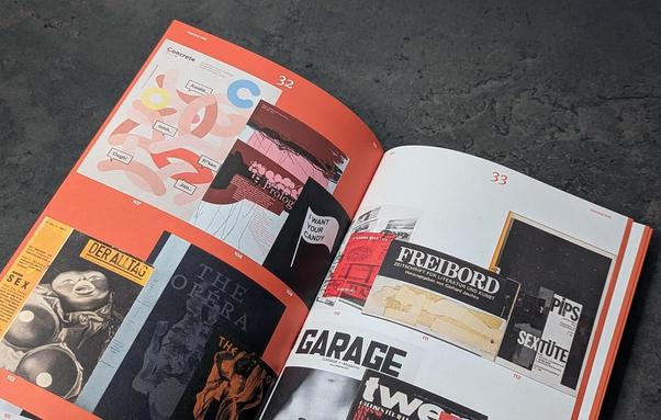 An open magazine featuring colorful graphic designs and various vintage magazine covers on a dark textured surface.
