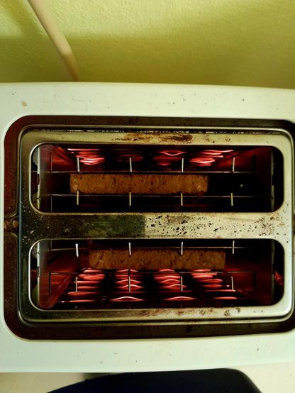 Filaments glow as toast toasts in the toaster, round side down.