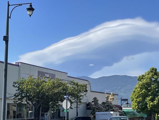 a zoomed in view shows the clouds looking large and ominous overtop a small business district.