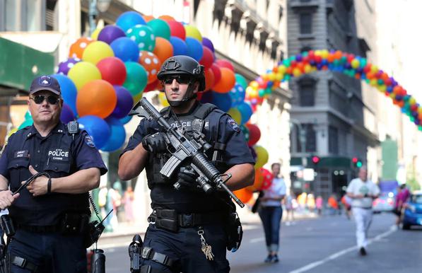 Police officers walk along the street near the parade route of the New York City Pride parade on 26 June 2016.