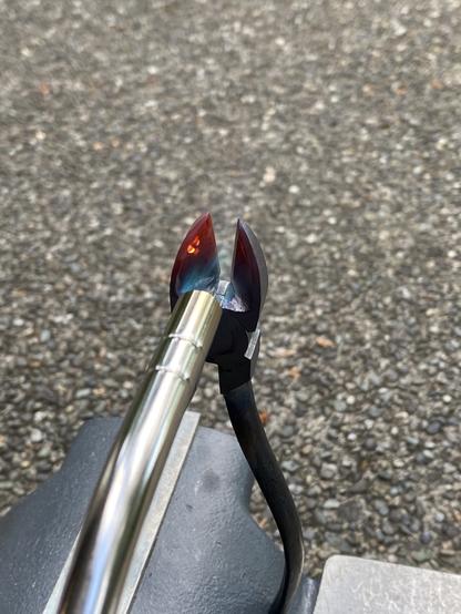 the same tool now with two red hotspots in the left blade of the wire cutters. the flame is still on the tool.
