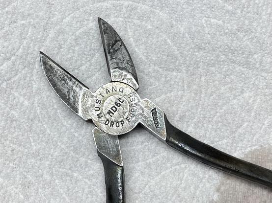back side of snips, still silver but way more mottled black line areas, all in various directions and shapes