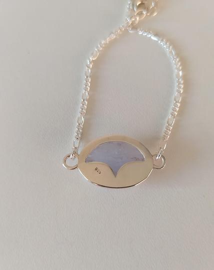 the back side of a silver bracelet placed in white background.