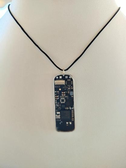 a pendant with an old PCB with black cord
