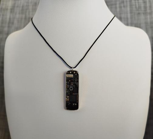 a pendant with an old PCB with black cord