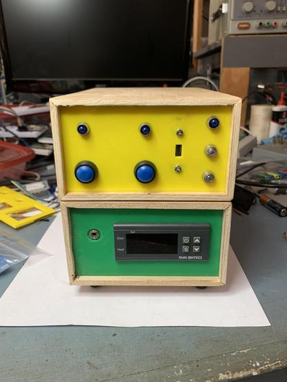 Outlet controller in yellow on top and temperature controller with green panel on the bottom