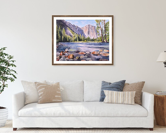 A large framed watercolor painting hangs on a wall above a couch.