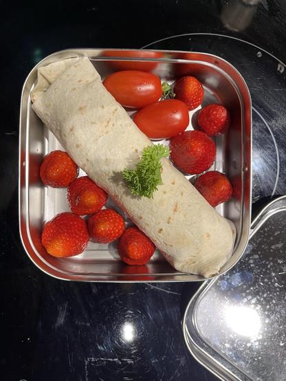 Tortilla Wrap mit Käse und Salat, zweo Tomätchen, drölf Erdbeeren und ein Blättchen Peterli - en Guete mitenand