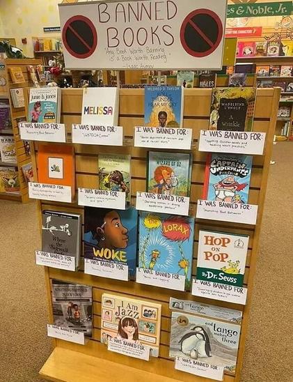 Picutre of a bookshelf with a sign saying, 
Banned Books: Any book worth banning is a book worth reading. 
-Isaac Asimov
The shelf features books and has signs explaining what each one was banned for.