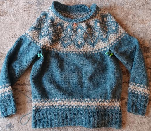 a blue with white patterned yoke sweater in an icelandic pattern.