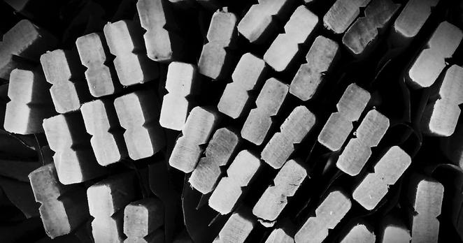 A black and white photo of the end of a bundle of chopsticks.