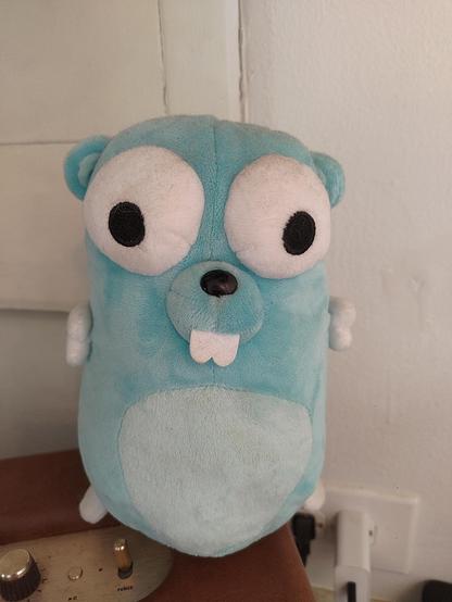 A light blue plush toy, ~7in tall, of the Go Gopher.