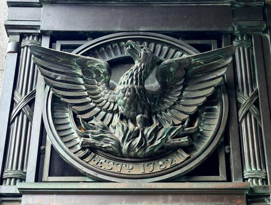 A bronze sculpture of a phoenix rising out of flames.