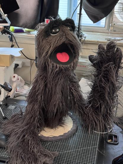 Grey furry live hands monster puppet with large glossy eyes, full body view